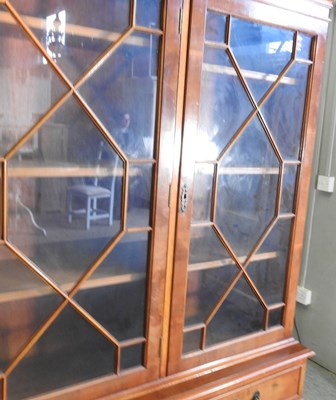 Lot 805 - A reproduction yew wood bookcase, on a plinth...