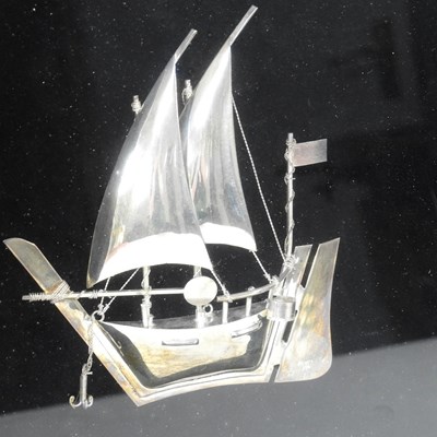 Lot 56 - A silver model of a junk ship, in a display...