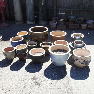 Lot 747 - A collection of glazed garden pots, highest...