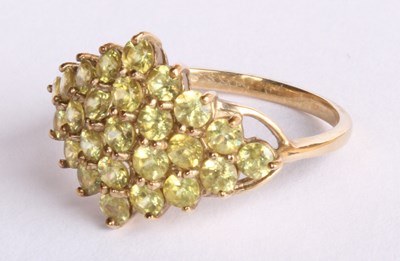 Lot 21 - A 9 carat yellow gold peridot cluster ring,...