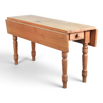 Lot 434 - A large pine drop leaf dining table, on turned...