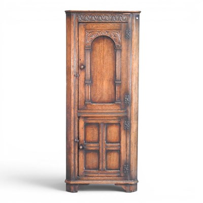 Lot 421 - An Old Charm style oak standing corner cabinet,...